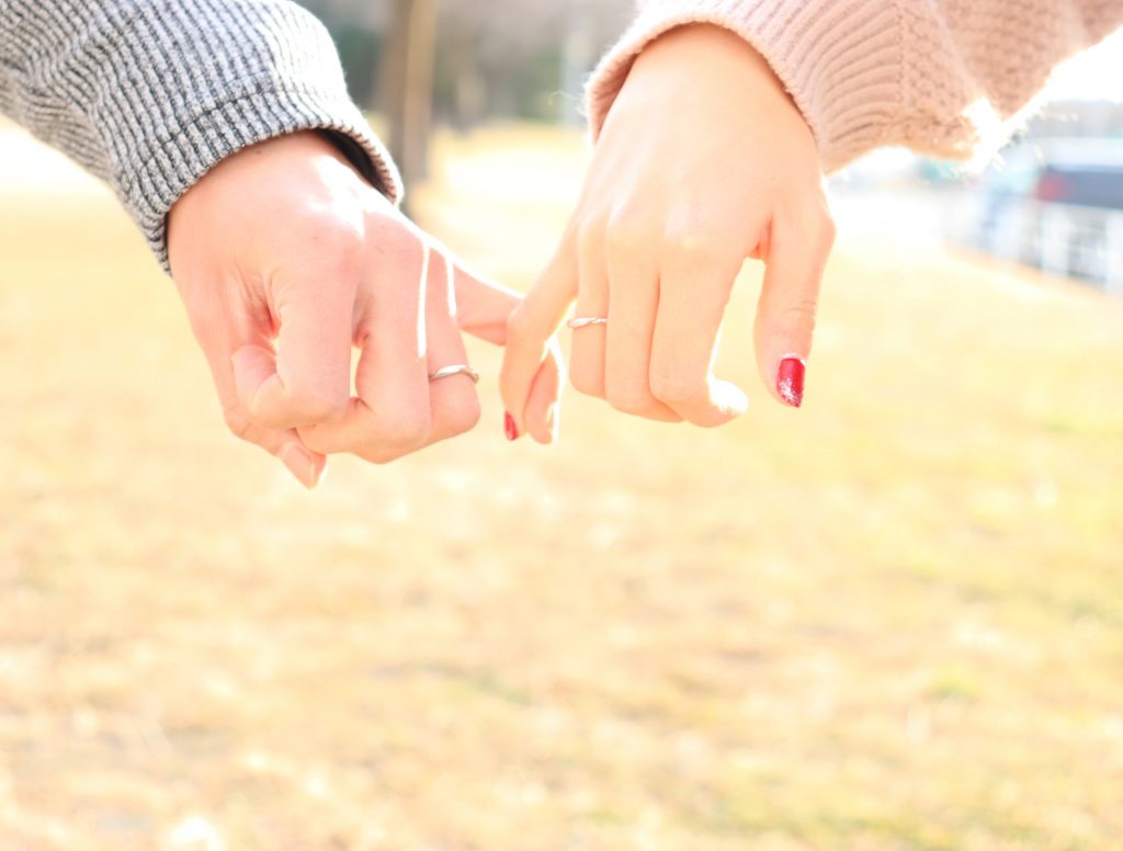 小指勾小指,並秀出婚戒